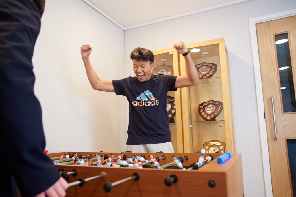 student cheering at foosball table